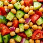 Fresh chickpea salad with cucumber, tomato, red onion, and herbs tossed in a light dressing